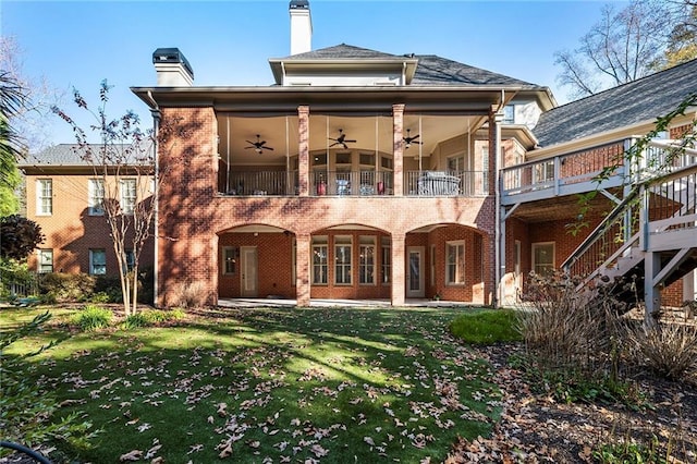 back of property featuring a yard, a balcony, and ceiling fan