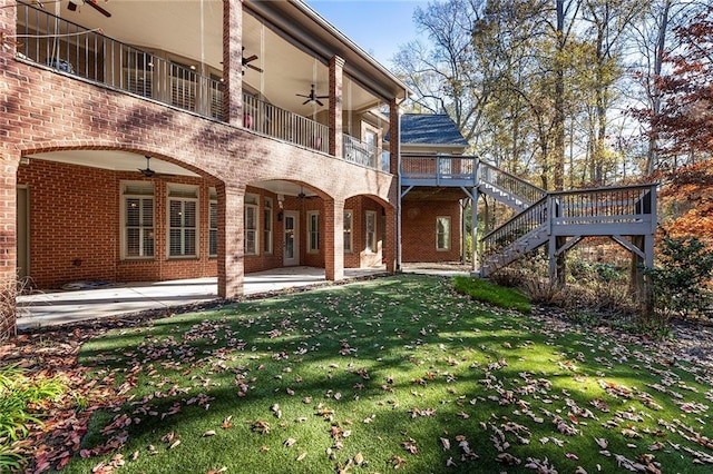 rear view of house with a patio area, a balcony, ceiling fan, and a lawn