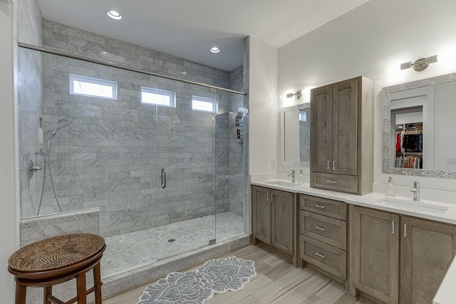 6014 Warpath Rd, Flowery Branch, GA 30542 - bathroom with a shower stall, double vanity, a walk in closet, and recessed lighting