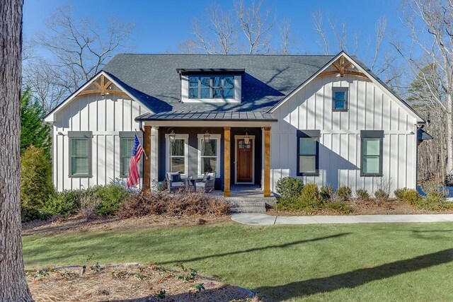 6014 Warpath Rd, Flowery Branch, GA 30542 - view of front of property with covered porch, board and batten siding, a standing seam roof, and a front yard