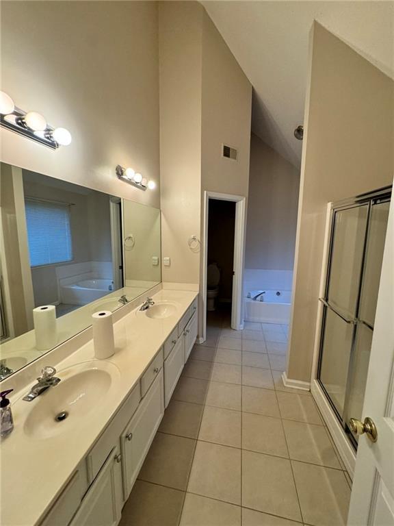 full bath with a garden tub, a sink, and tile patterned floors