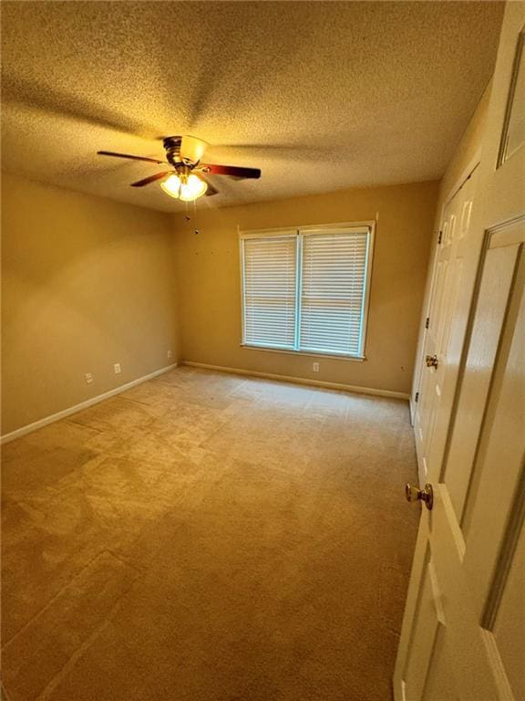 unfurnished bedroom with light carpet, baseboards, and a textured ceiling