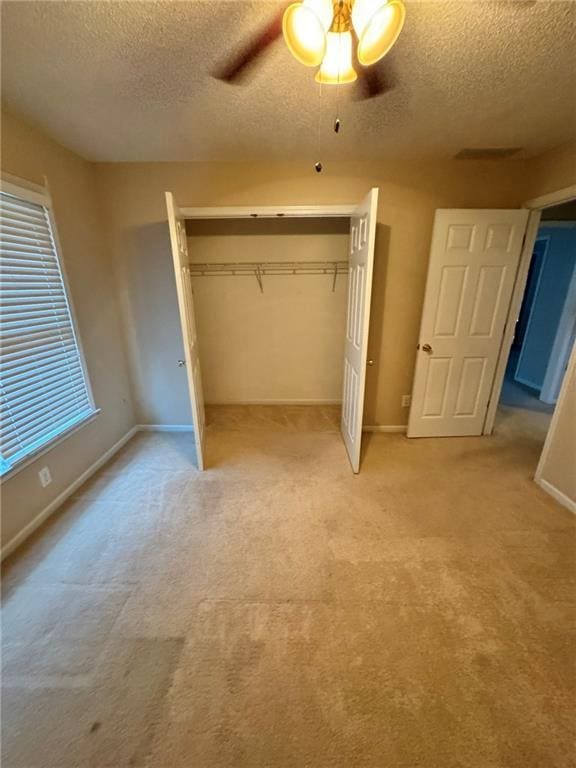 unfurnished bedroom with a closet, light carpet, and baseboards