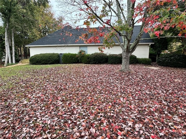 view of side of home with a shingled roof