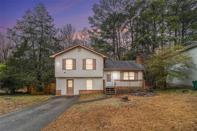 split level home featuring a lawn and a deck