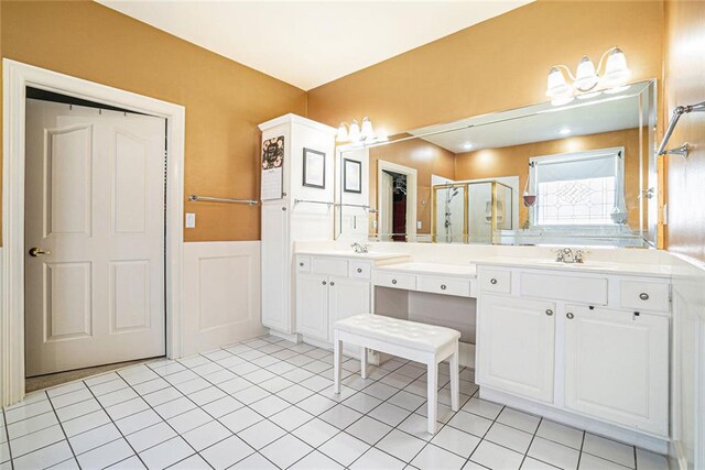725 Windsor Place Cir SW, Grayson, GA 30017 - bathroom featuring a stall shower, wainscoting, double vanity, tile patterned flooring, and a decorative wall