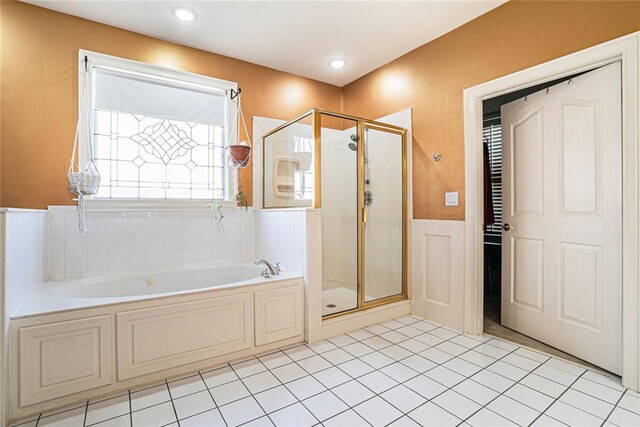 725 Windsor Place Cir SW, Grayson, GA 30017 - bathroom featuring a garden tub, a stall shower, wainscoting, tile patterned floors, and a decorative wall