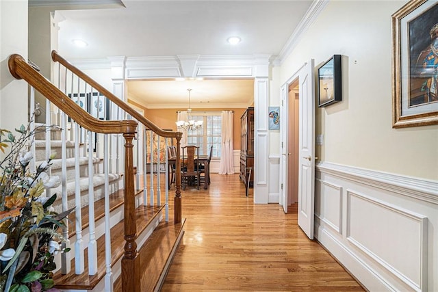 725 Windsor Place Cir SW, Grayson, GA 30017 - hallway with a chandelier, crown molding, light wood finished floors, stairway, and wainscoting
