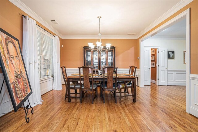 725 Windsor Place Cir SW, Grayson, GA 30017 - dining space with a chandelier, plenty of natural light, light wood-style flooring, crown molding, and a decorative wall