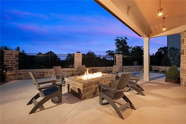 patio terrace at dusk featuring a fire pit