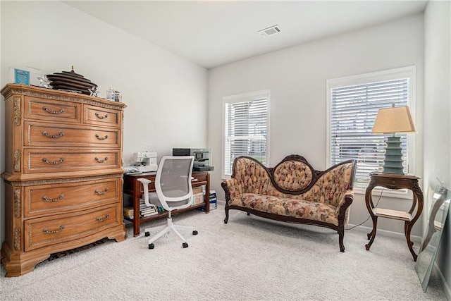 office with visible vents, baseboards, and light carpet