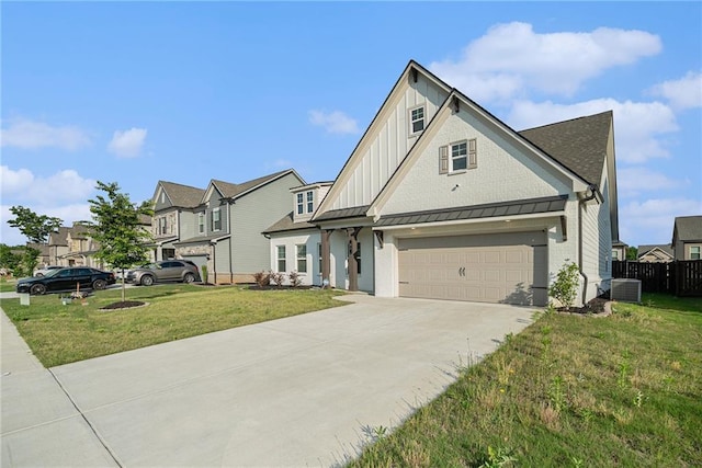 view of front of home featuring board and batten siding, a standing seam roof, a front yard, central AC unit, and concrete driveway