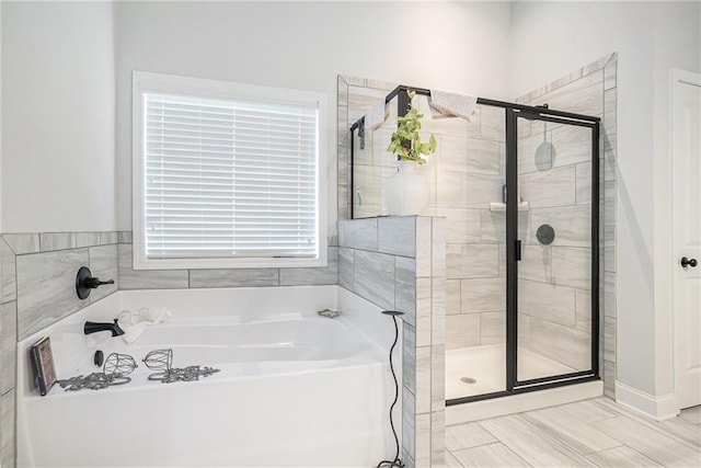 bathroom with a shower stall and a bath