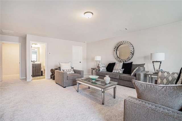 living room featuring baseboards, visible vents, and light carpet