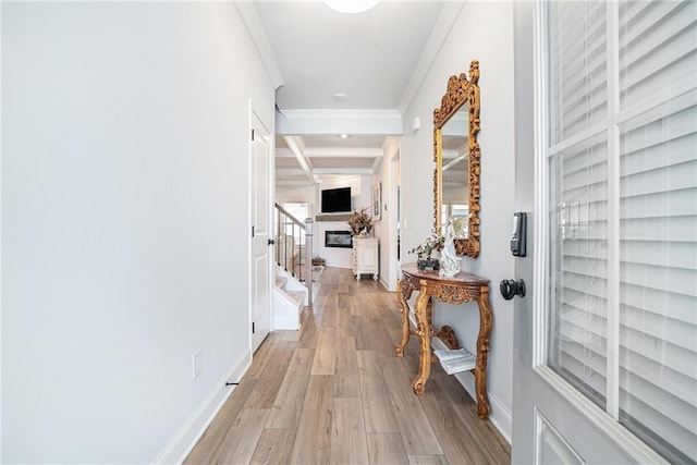 hallway with beam ceiling, baseboards, ornamental molding, coffered ceiling, and light wood-style flooring