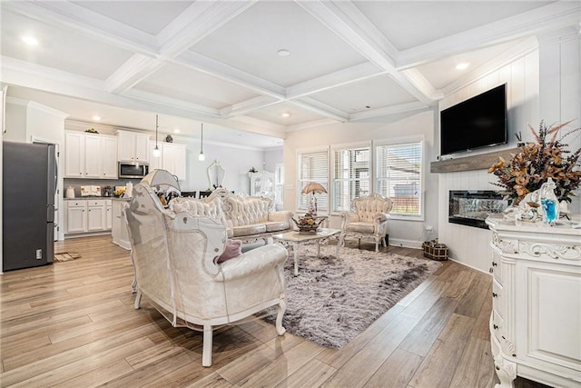 living room featuring a glass covered fireplace, beam ceiling, light wood finished floors, and coffered ceiling