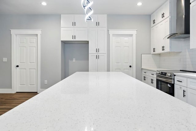 112 Radian Ct, Dallas, GA 30132 - kitchen featuring wall chimney range hood, stainless steel range with electric stovetop, dark wood finished floors, light stone counters, and recessed lighting