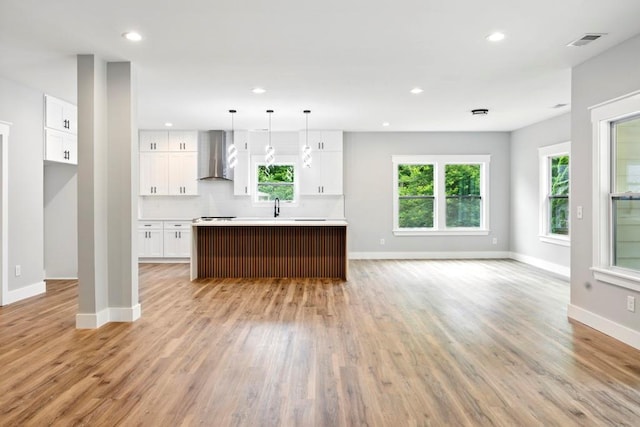 112 Radian Ct, Dallas, GA 30132 - kitchen featuring wall chimney exhaust hood, open floor plan, baseboards, a sink, and light wood-style floors