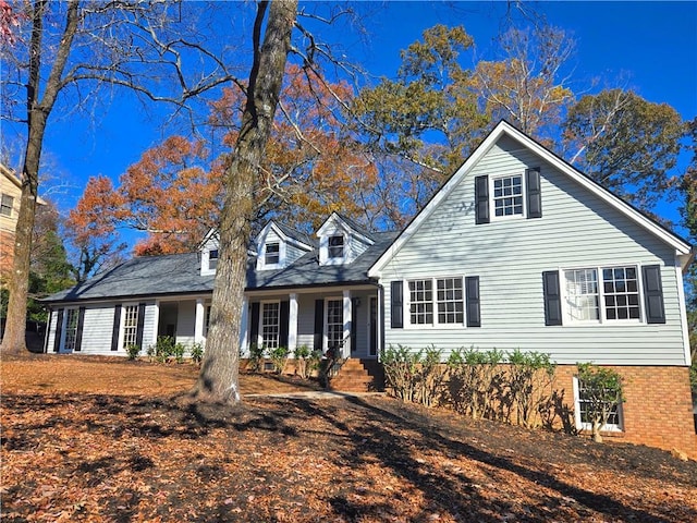 new england style home featuring covered porch