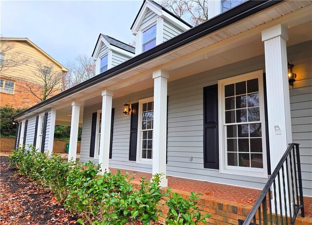 view of side of property featuring covered porch