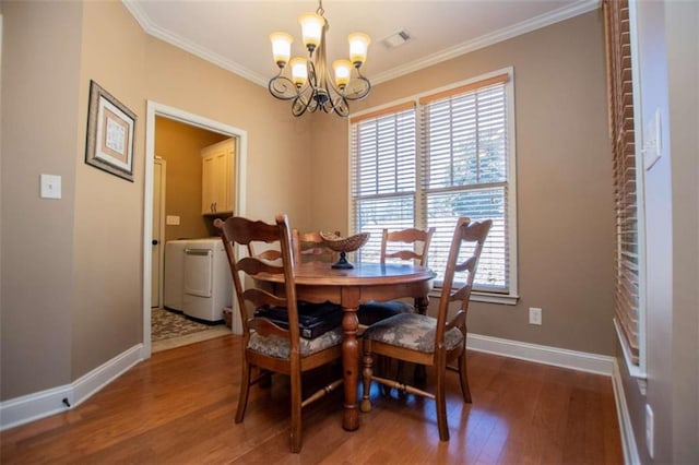 dining area featuring visible vents, washer / clothes dryer, a chandelier, and crown molding