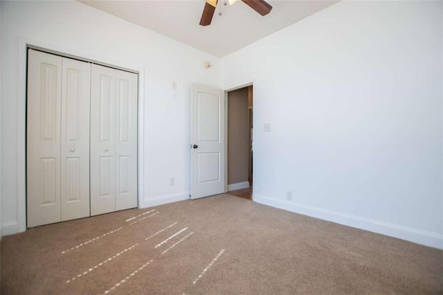 unfurnished bedroom featuring a closet, baseboards, ceiling fan, and carpet flooring