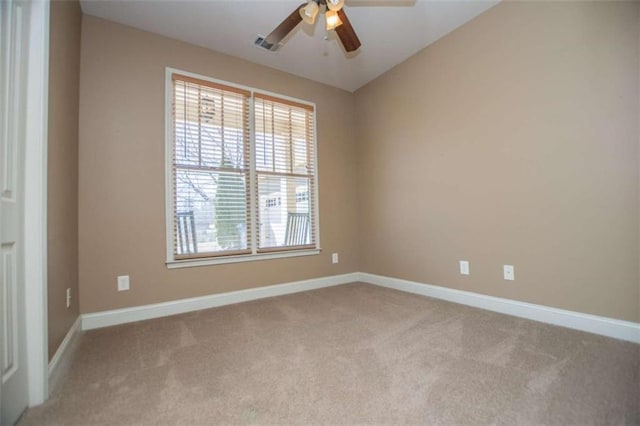 carpeted empty room featuring visible vents, baseboards, and ceiling fan