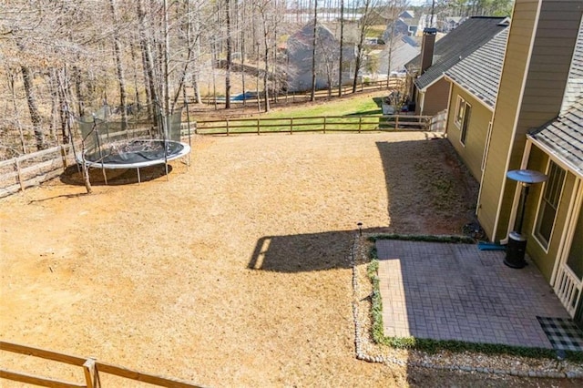 view of yard with a patio, a trampoline, and fence