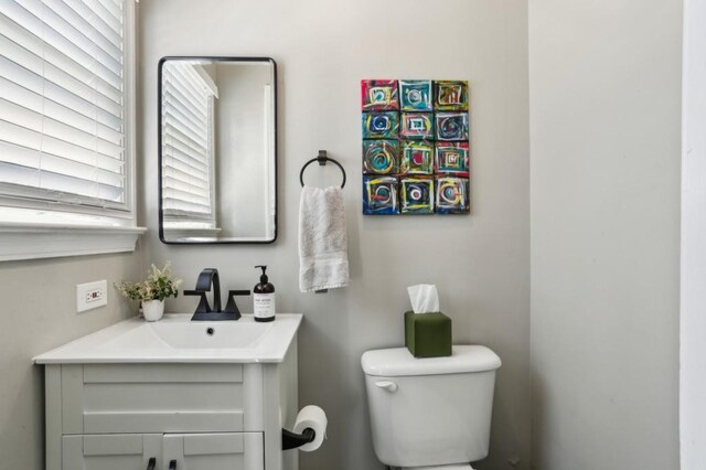half bathroom with vanity and toilet