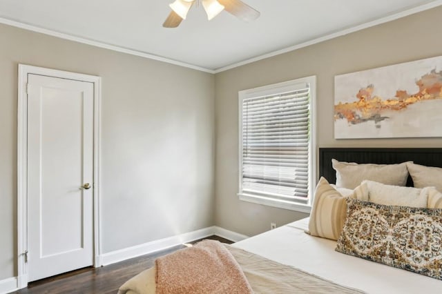 bedroom featuring baseboards, ornamental molding, wood finished floors, and multiple windows