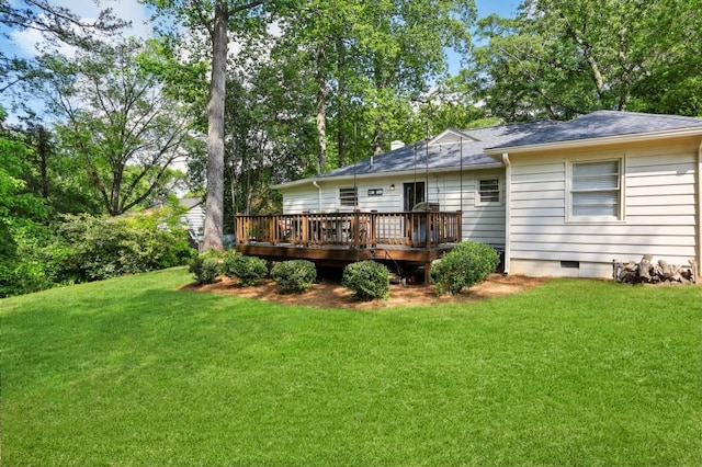 back of property featuring a lawn, a wooden deck, roof with shingles, and crawl space