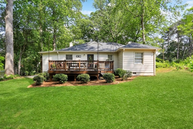 rear view of property featuring a lawn, crawl space, a chimney, and a deck