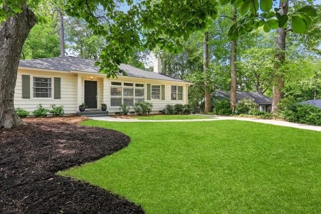ranch-style home featuring a chimney and a front yard