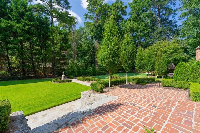 view of home's community featuring a lawn and a patio