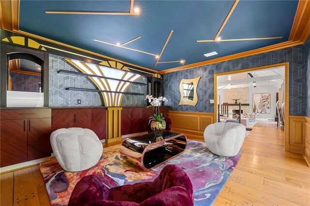 living area with light hardwood / wood-style flooring and ornamental molding