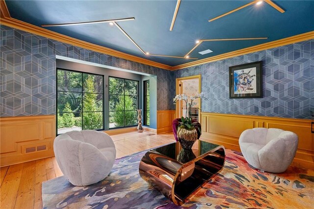 sitting room featuring ornamental molding and hardwood / wood-style floors