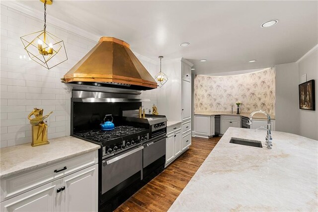 kitchen featuring light stone counters, sink, decorative light fixtures, dark wood-type flooring, and custom range hood