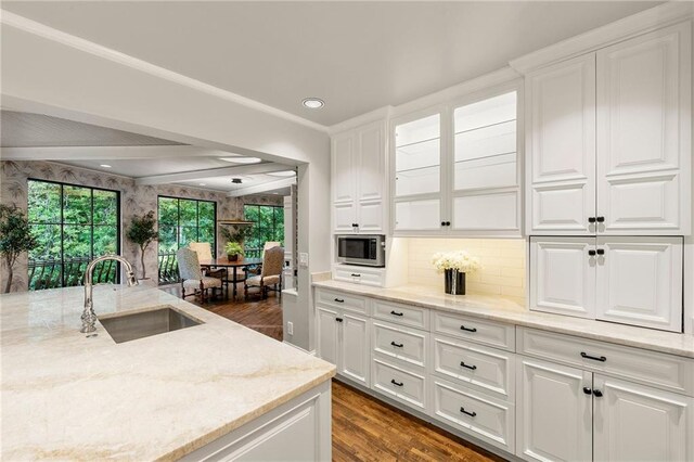 kitchen with white cabinetry, stainless steel microwave, dark wood-type flooring, and sink