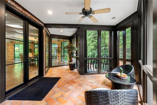 sunroom / solarium with vaulted ceiling, ceiling fan, and french doors