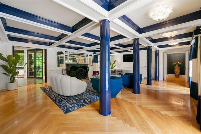 living room with parquet flooring, beamed ceiling, an inviting chandelier, crown molding, and french doors