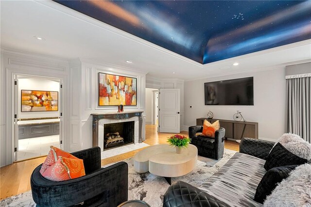 living room featuring ornamental molding, light hardwood / wood-style flooring, and a premium fireplace