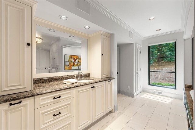 bathroom featuring tile patterned flooring, a tub to relax in, vanity, and crown molding