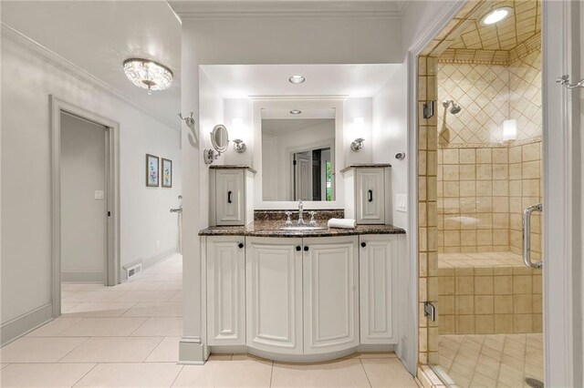 bathroom with tile patterned flooring, a shower with shower door, vanity, and crown molding