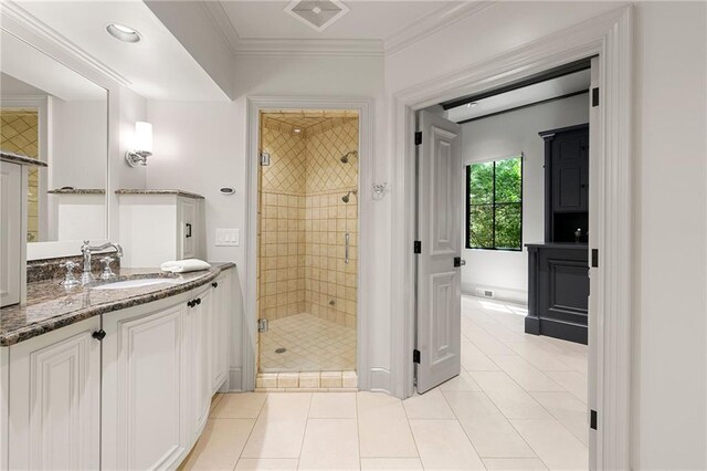 bathroom featuring ornamental molding, vanity, a shower with shower door, and tile patterned flooring