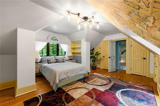 bedroom with light hardwood / wood-style floors and lofted ceiling