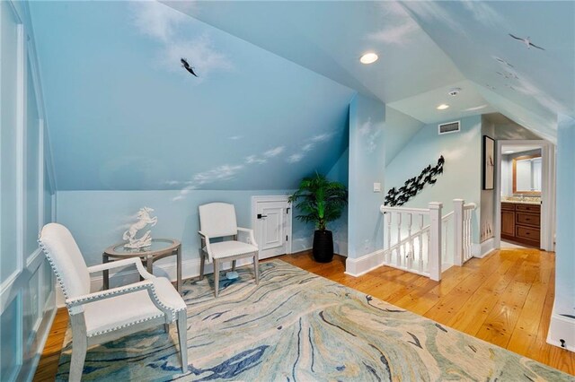 living area featuring light hardwood / wood-style flooring and vaulted ceiling