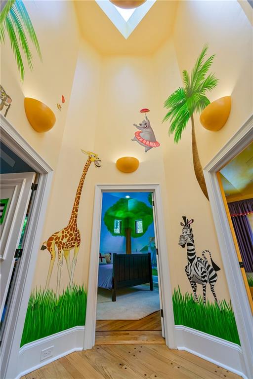 hallway featuring hardwood / wood-style floors and a skylight