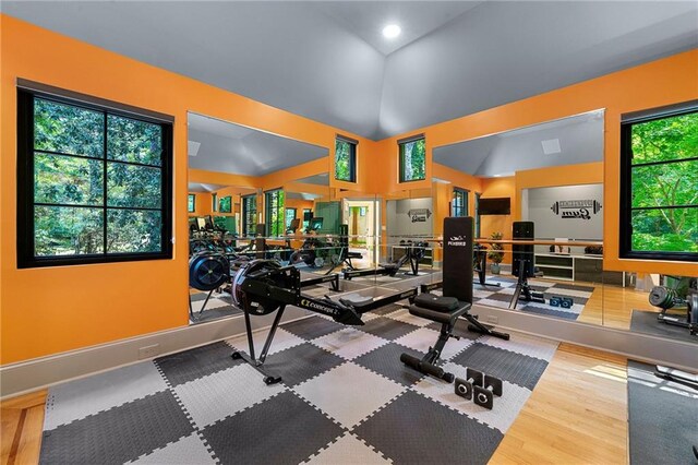 workout room featuring wood-type flooring and vaulted ceiling