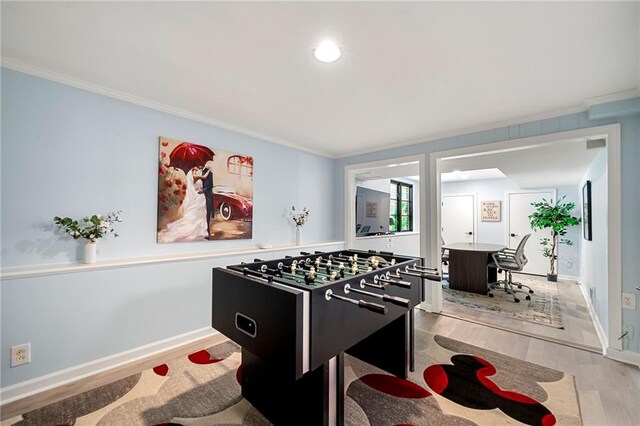 rec room with light hardwood / wood-style flooring and crown molding