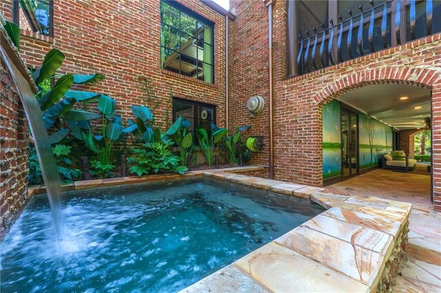 view of pool with a jacuzzi and a patio